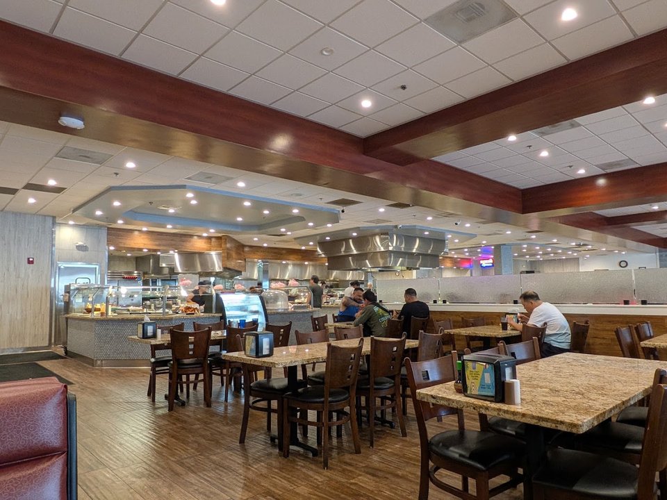 Mongolian grill station beside hot trays